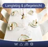 A beautifully set dining table with a white tablecloth, place settings, and candles. Produktbild-Vorschau