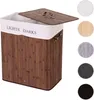 A laundry basket with two compartments and a lid, made of bamboo and fabric, shown with color options on the side. Produktbild-Vorschau