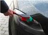 A person is washing a car headlight with a brush. Produktbild-Vorschau