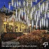 A house decorated with Christmas lights during a snowfall. Produktbild-Vorschau
