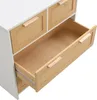 A close-up view of a white dresser with wooden drawer fronts featuring cane detailing. One drawer is open, revealing the interior. Podgląd zdjęcia produktu