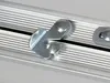 A close-up view of a metal latch mechanism on a ribbed aluminum track. Anteprima dell’immagine prodotto