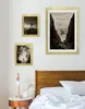 Three framed pictures are displayed on a wall above a bed. Produktbild-Vorschau