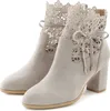A pair of light gray lace-trimmed ankle boots with block heels, presented against a white background. Produktbild-Vorschau