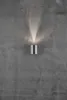 A silver cylinder-shaped LED wall light is mounted on a textured gray concrete wall, casting a beam of light upwards and downwards. Anteprima dell’immagine prodotto