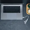 A top-down view of a laptop with a USB hub connected. Produktbild-Vorschau