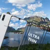 A white Samsung Galaxy A70 phone is shown next to a tempered glass screen protector, with a scenic background of mountains and a village. Produktbild-Vorschau