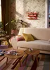 A cozy living room scene with a sofa, coffee tables, and decorative items. Produktbild-Vorschau