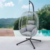 A hanging egg chair is placed on a patio next to a swimming pool, with a lush green landscape and mountains in the background. Produktbild-Vorschau