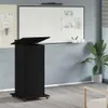 A black podium with an open top stands in an office or classroom setting, with a whiteboard in the background. Anteprima dell’immagine prodotto
