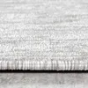 A close-up, side view of the edge of a light gray textured rug. Produktbild-Vorschau