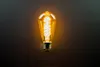 A single Edison-style LED light bulb is shown against a dark background. Produktbild-Vorschau