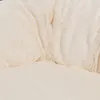 A close-up view of a soft, fluffy, cream-colored dog bed. Produktbild-Vorschau