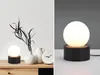 A collage of two images showing a modern black table lamp with a white globe light. Náhľad obrázku produktu