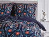 A close-up view of a dark blue duvet cover and pillowcases with a colorful folk-inspired pattern, set on a bed. Náhled obrázku produktu