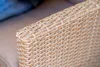 A close-up view of the woven texture of an outdoor furniture armrest. Náhľad obrázku produktu