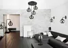A modern living room with a sectional sofa, coffee table, floor lamps, wall sconces, and a pendant light. Produktbild-Vorschau