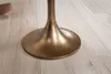 Close-up of the base of a gold-colored table on a light wooden floor. Voir les images du produit
