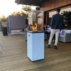People gathered on a wooden deck around a gas patio heater at dusk. Produktbild-Vorschau