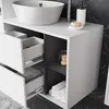 A close-up view of a white bathroom vanity with drawers and a sink. Náhled obrázku produktu