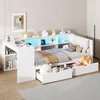 A white bed frame with integrated desk and storage drawers, illuminated by LED lights. Náhľad obrázku produktu