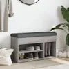A shoe bench with storage in a hallway next to a plant and a hanging garment. Náhľad obrázku produktu