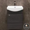 A close-up view of a modern bathroom vanity with a white sink and a dark gray cabinet, set against a marble-patterned tiled wall. Produktbild-Vorschau