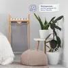 A corner of a room with a laundry basket, plants, and a pouf. Produktbild-Vorschau