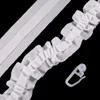 A close-up view of white curtain tape with pleats and a plastic hook against a black background. Produktbild-Vorschau
