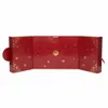 A red advent calendar with gold floral accents and numbered doors. Produktbild-Vorschau