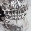 A close-up view of a silver-colored skull sculpture with detailed teeth. Podgląd zdjęcia produktu