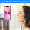 A woman wearing headphones listens to music from a smartphone connected by an audio cable. Produktbild-Vorschau