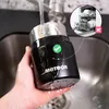 A hand holding a black Meteor thermobehälter under running water in a sink. An inset image shows a dishwasher with a red cross symbol. Náhled obrázku produktu
