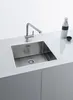 A stainless steel kitchen sink with a modern faucet, set on a white countertop. Podgląd zdjęcia produktu