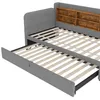 A close-up view of a grey upholstered bed frame with a pull-out trundle bed and a wooden shelf headboard. Náhled obrázku produktu