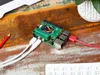 A Raspberry Pi 5 with an M.2 HAT+ connected to cables, placed on a wooden desk next to a red pencil and a keyboard. Anteprima dell’immagine prodotto