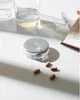 A pillbox with pills scattered around it, next to glasses of water and a magazine. Produktbild-Vorschau
