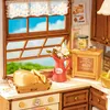 A miniature kitchen scene with bread, a vase of flowers, and jars on a countertop. Náhľad obrázku produktu