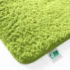 Close-up of a fluffy green bath mat with a label attached. Anteprima dell’immagine prodotto