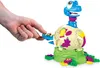 A child's hand is shown interacting with a colorful toy dinosaur emerging from an egg. Produktbild-Vorschau