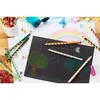 A collection of STABILO colored pencils and art supplies are arranged on a wooden surface, with children's drawings in the background. Anteprima dell’immagine prodotto