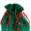 A close-up view of the top of a green drawstring gift bag with a white snowflake and star pattern, tied with red ribbons. Produktbild-Vorschau