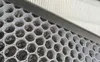 Close-up of a dirty air filter with a honeycomb-like structure filled with dark debris. Produktbild-Vorschau