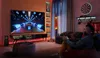 A person is playing a video game on a large TV in a dimly lit room. Produktbild-Vorschau