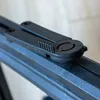 Close-up of a black plastic mechanism on a dark gray textured surface. Produktbild-Vorschau