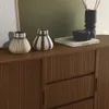 A wooden buffet with two sliding doors, decorated with two vases and a book. Anteprima dell’immagine prodotto