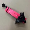 A red and black bicycle brake caliper tool is shown on a light brown surface. Produktbild-Vorschau