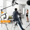 A photographer is setting up a shot with a model in a studio. Produktbild-Vorschau