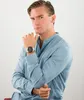 A man wearing a blue shirt and a watch is posing against a white background. Produktbild-Vorschau