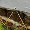 A close-up shot of a gray PVC tarp covering a stack of firewood. Yellow bungee cords are used to secure the tarp to the firewood. Water is dripping from the tarp onto the wood. Náhled obrázku produktu